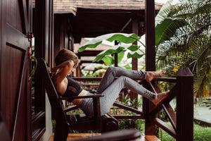 model leaning back in chair in tropical setting